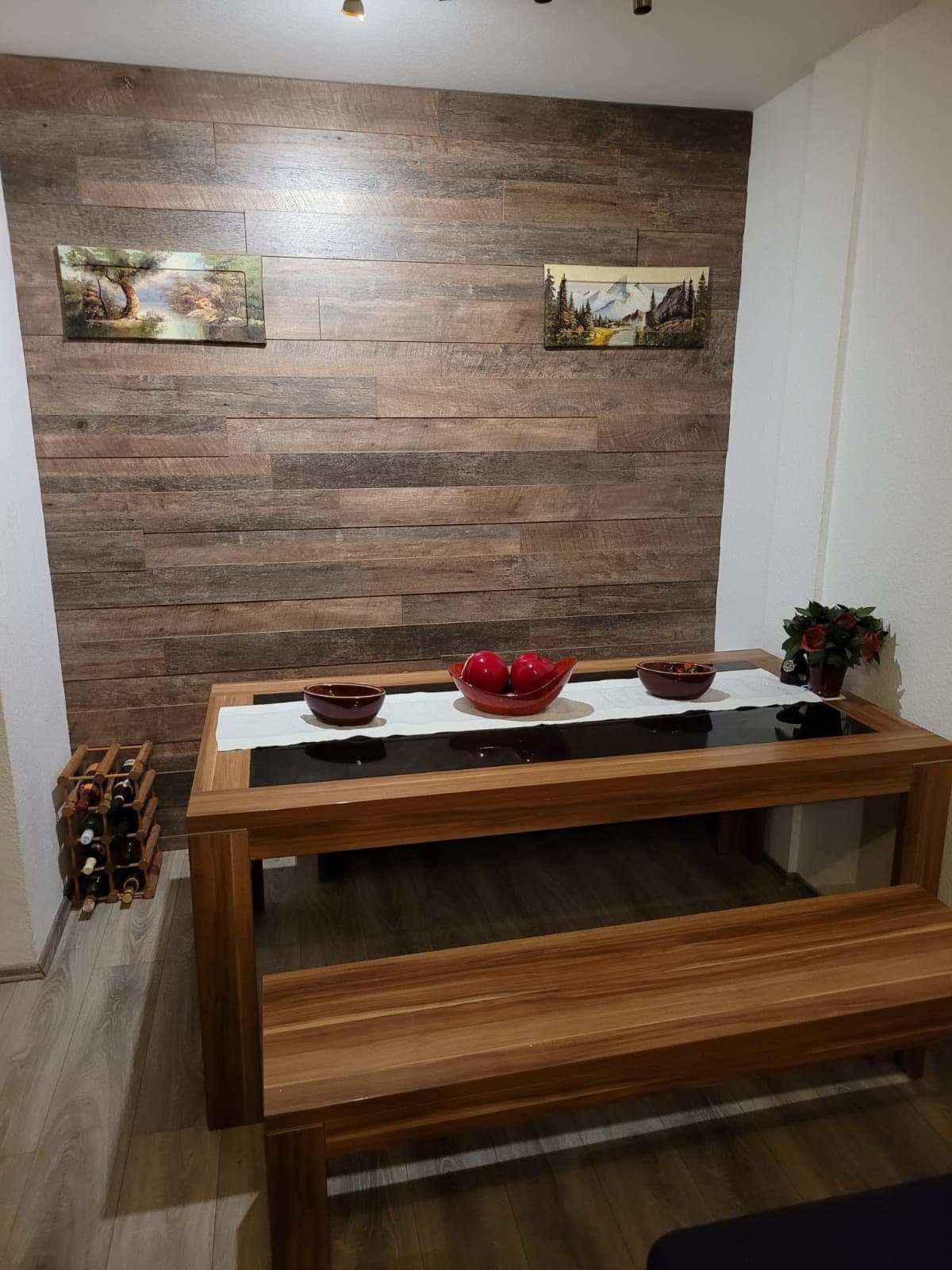 Esszimmer mit vollflächiger Wandverkleidung in Altholzoptik und massivem Holztisch