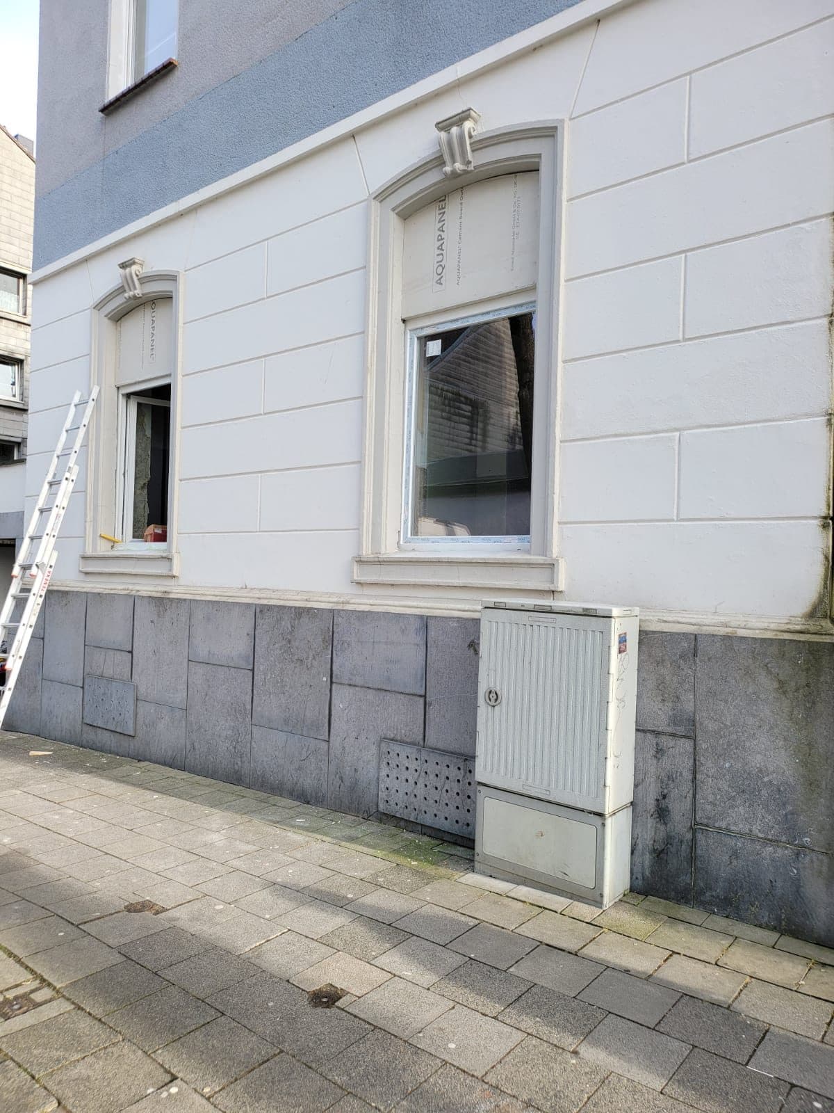 Gesamtansicht der hellen Altbaufassade mit den neu eingesetzten Fenstern
